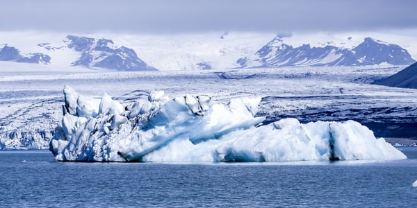 Isberg i hav foran snødekkede fjell